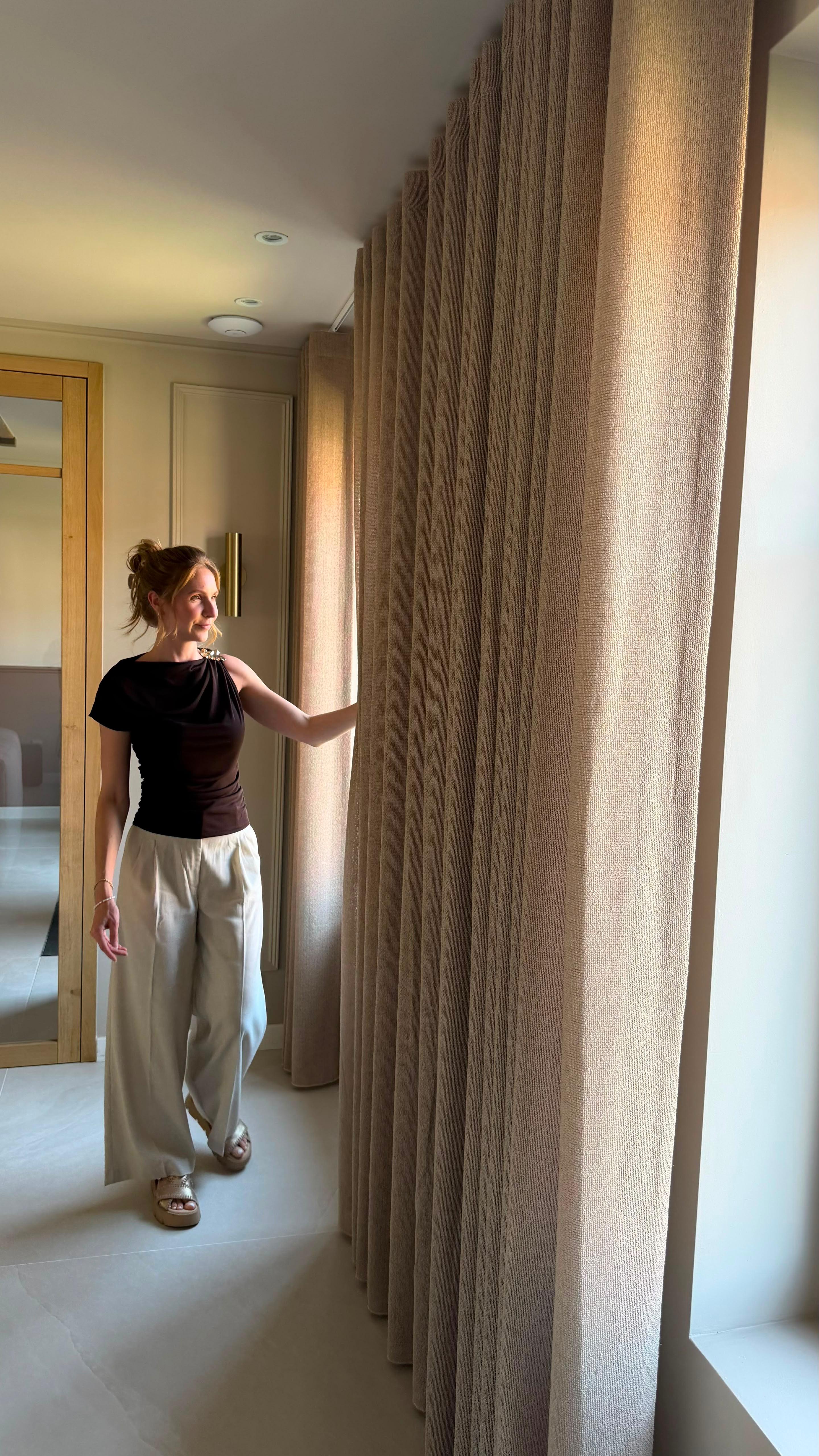 Vloerlange zandkleurige gordijnen in een lichte slaapkamer